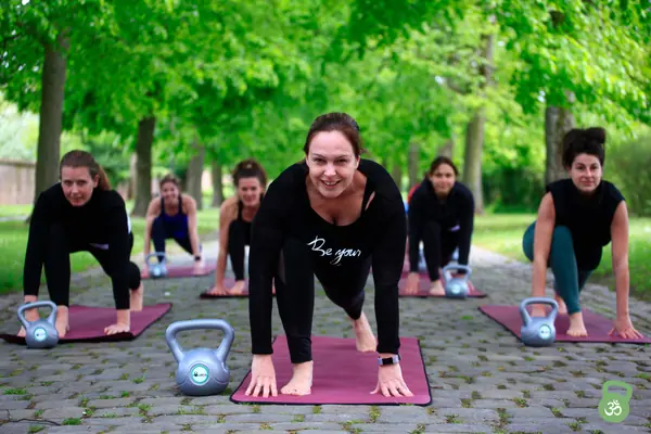 Deelnemers in plankpositie op de yogamat
