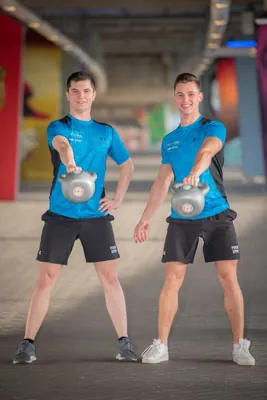Twee deelnemers trainen samen met de kettlebell